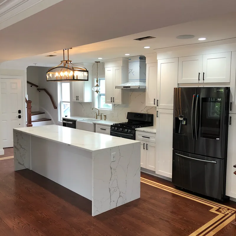 Waterfall end of the Calacatta quartz island, the veining running down the side panel over an inlaid wood floor, Osterville, MA