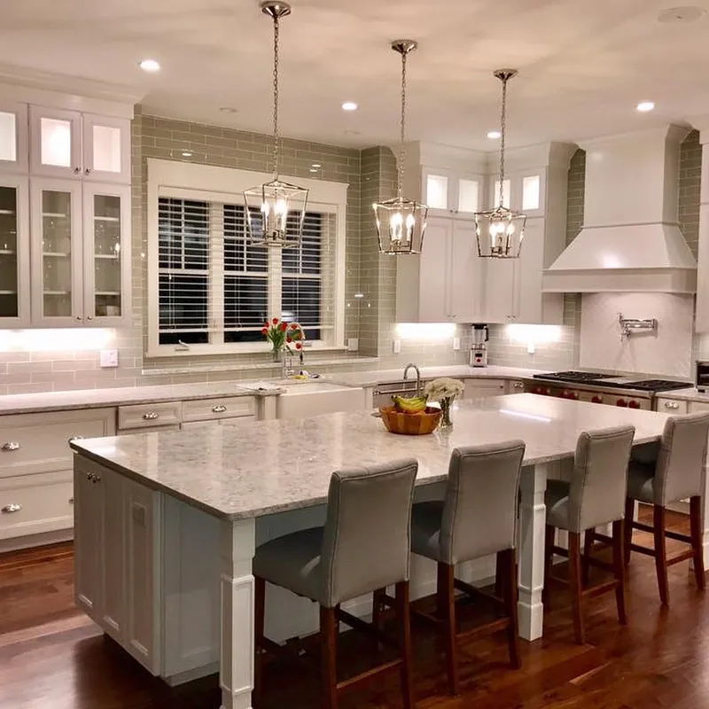 White kitchen with a long quartz island, lantern pendants and gray stools, Leominster, MA